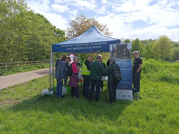 seven people stand infront of a table in a park. A gazebo over the table reads: Tyne RIvers Trust, working together to manage and improve our river